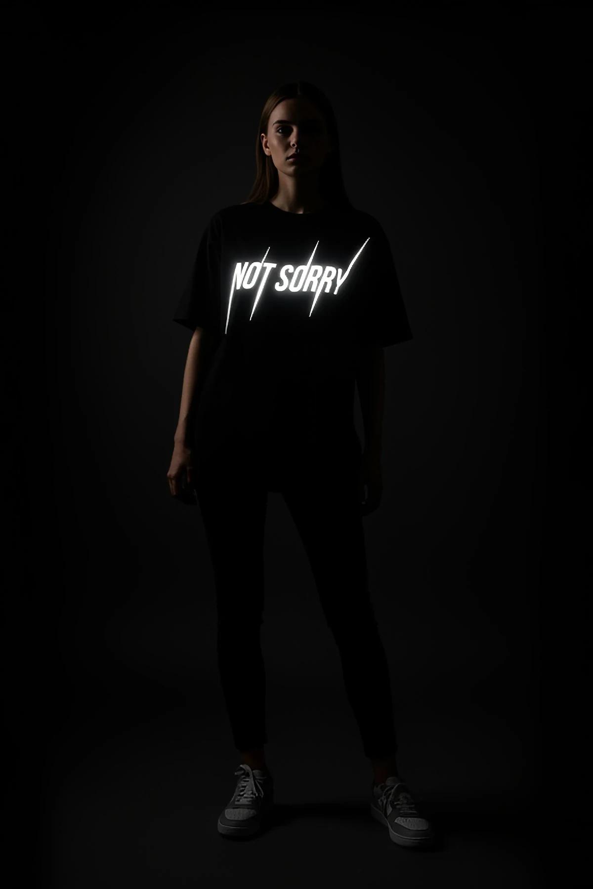 NOT SORRY reflektörlü tişört model üzerinde tam boy ön görünüm karanlık fotoğraf