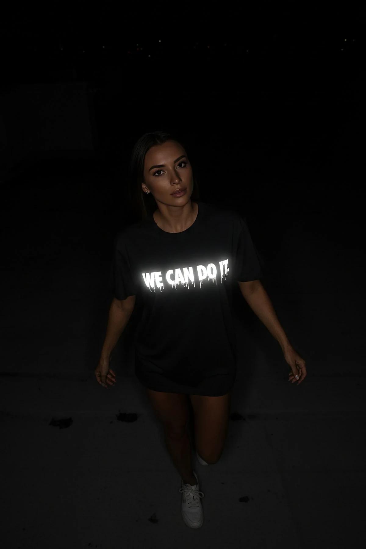 WE CAN DO IT. drip reflektör baskılı siyah oversize tişört, ön görünüm karanlıkta parlama