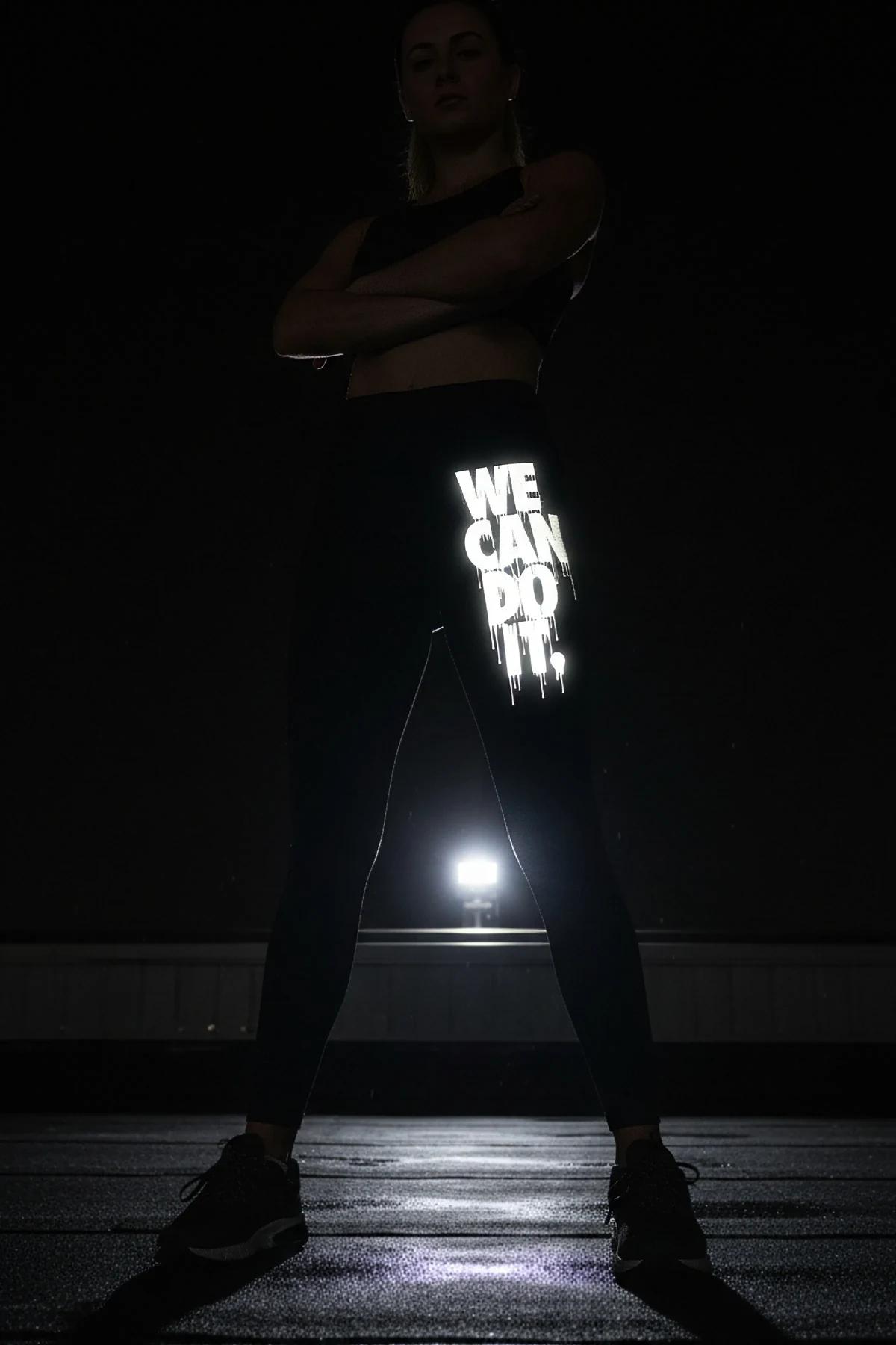 WE CAN DO IT drip baskılı siyah tayt model üzerinde önden görünüm gece çekimi