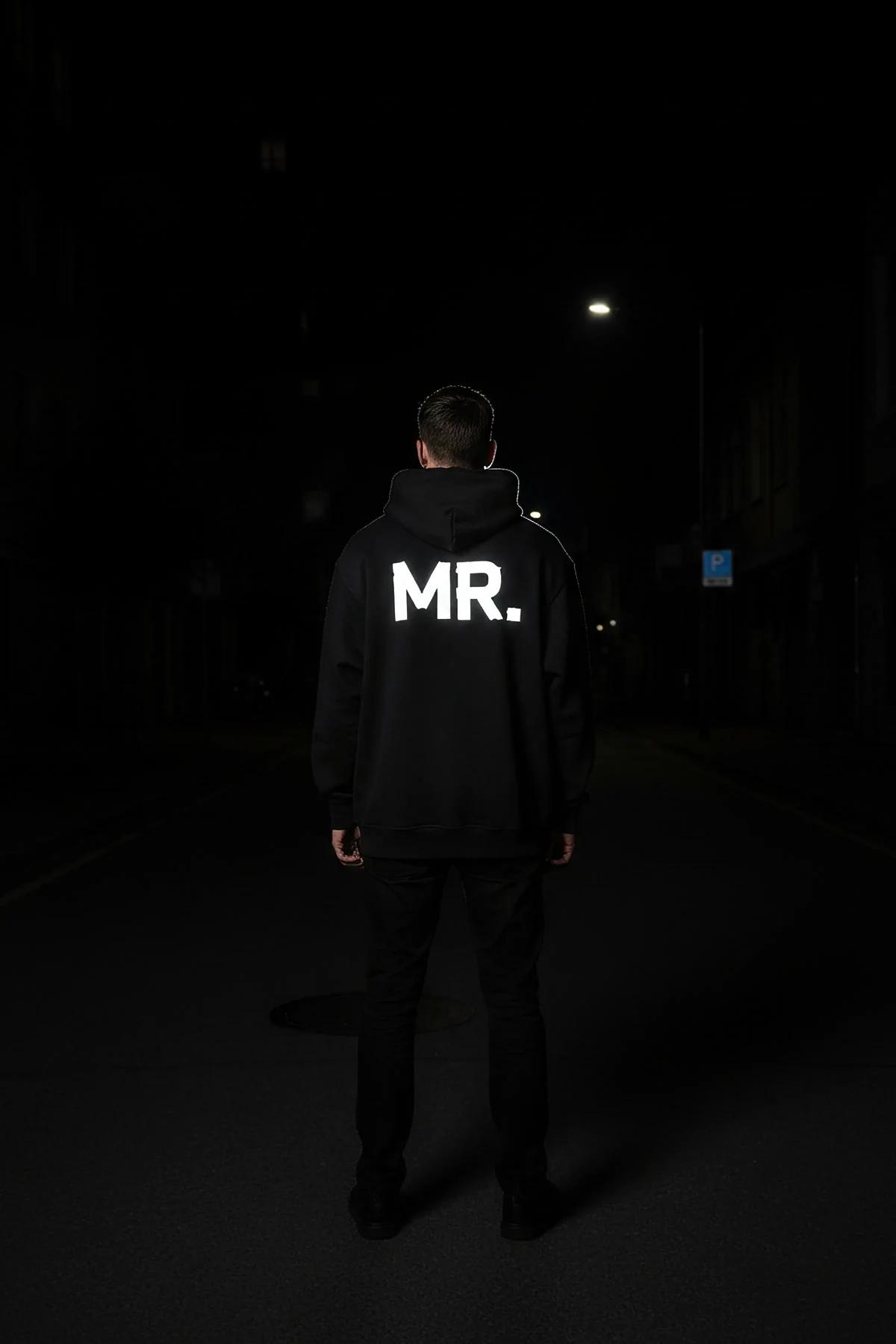 MR. reflektörlü sırt baskılı siyah kapüşonlu oversize sweatshirt, erkek model sırttan gece çekimi