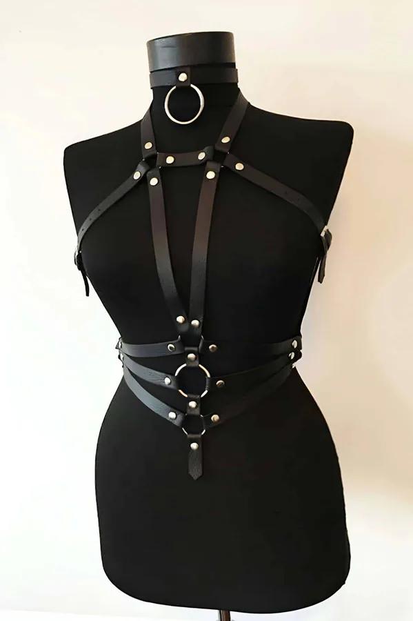 Model wearing black Adjustable Vegan Leather Chest Harness Top with silver alloy hardware and caged strap details front view
