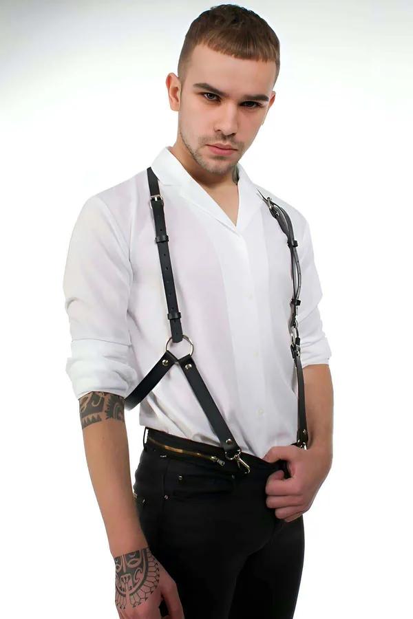 Black faux leather men's body harness with silver O-ring chest detail and trouser clips worn over white shirt